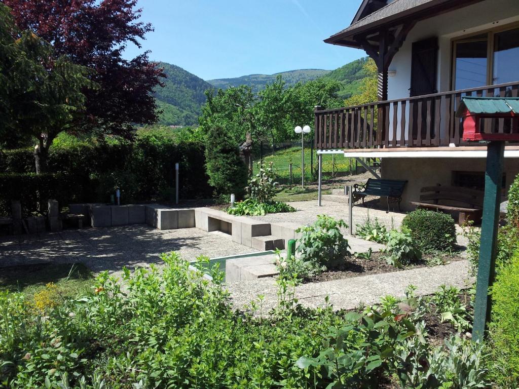 a garden in front of a house with mountains in the background at Gite Bellevue in Breitenbach