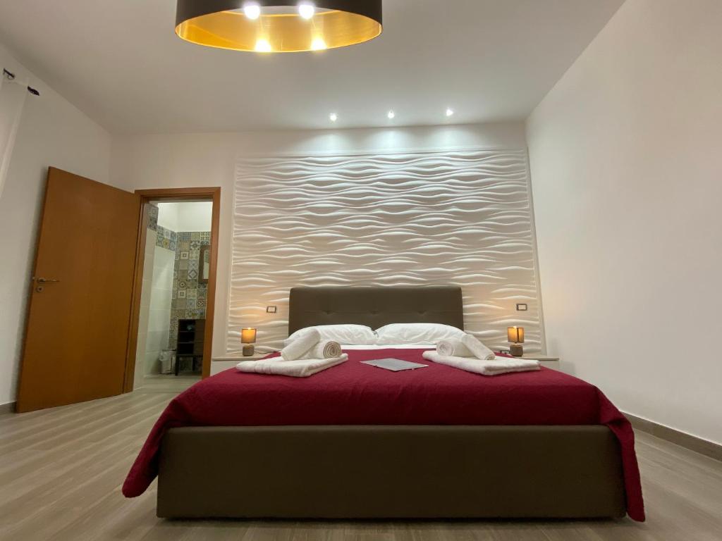 una camera da letto con un grande letto con una coperta rossa di Seacily house a Mazara del Vallo