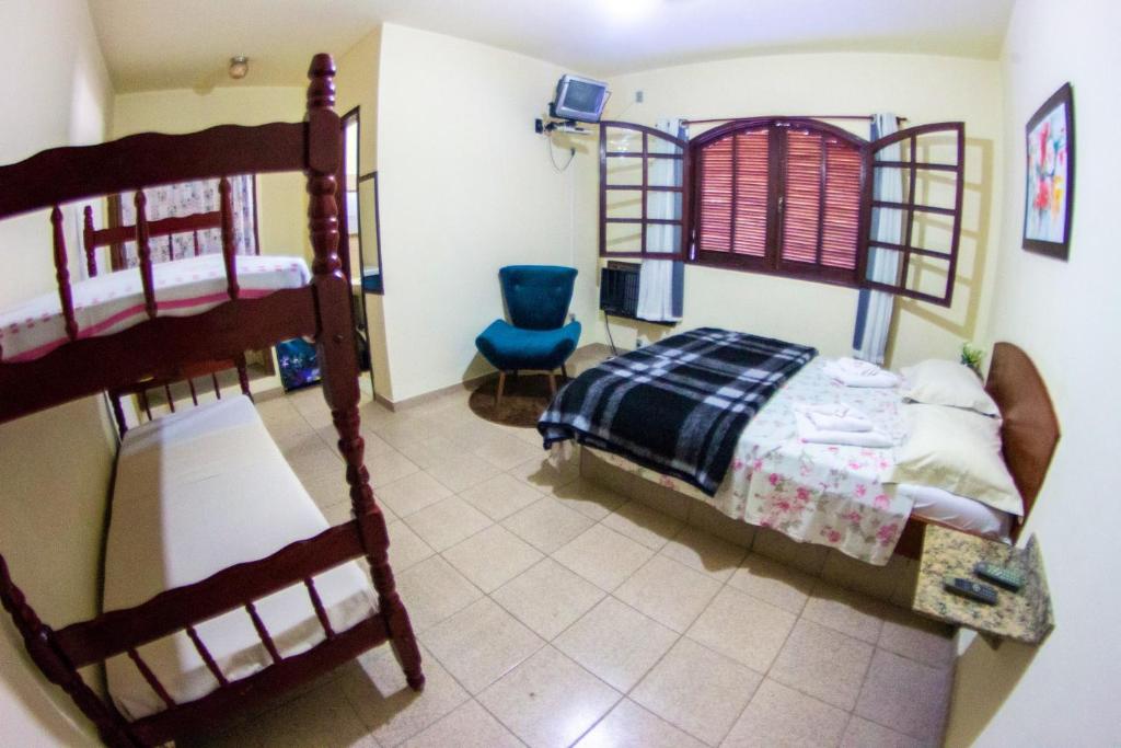 a bedroom with two bunk beds and a blue chair at Pousada Lagoa de Araruama in Araruama
