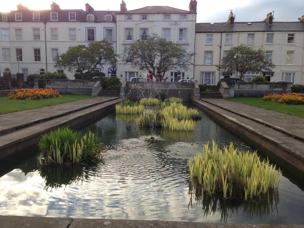 a canal in front of a building with grass in the water at Admiral Hotel in Scarborough