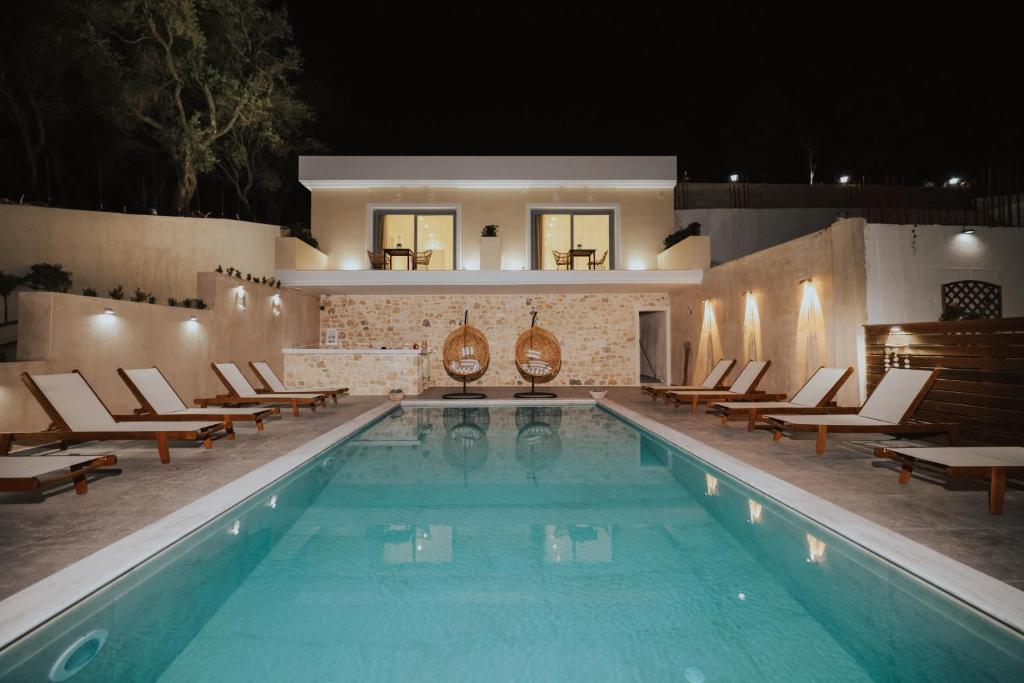 a swimming pool with lounge chairs and a swimming pool at Liberte Maisonettes in Parga