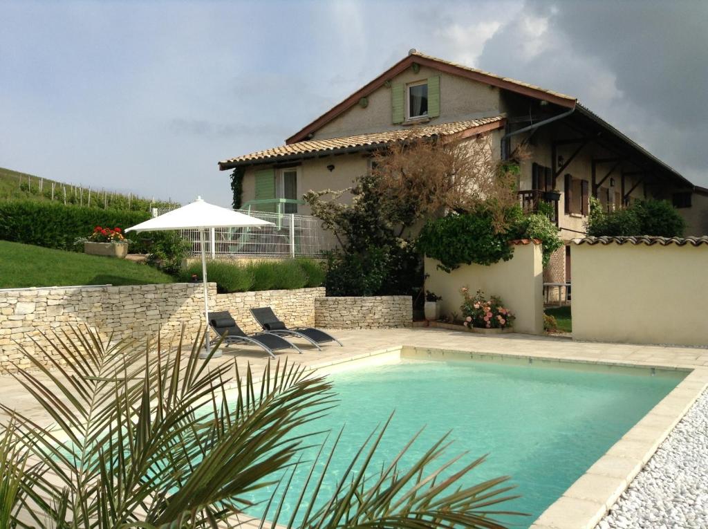 uma piscina em frente a uma casa em La Croix de Saburin em Quincié-en-Beaujolais