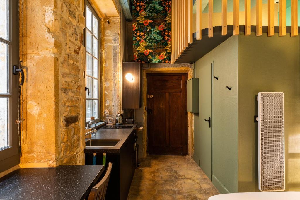 a kitchen with a sink and a hallway with a staircase at DIFY Platiere - Hotel de Ville in Lyon
