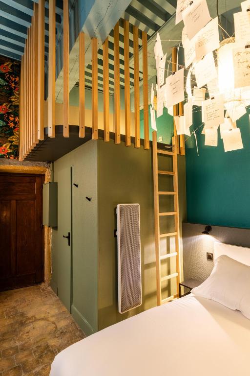 a bedroom with a bed and a staircase with notes on the wall at DIFY Platiere - Hotel de Ville in Lyon