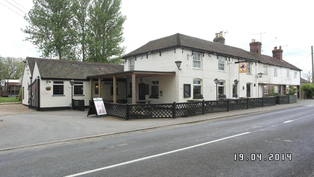 un edificio blanco al lado de una calle en The Hawkenbury en Staplehurst