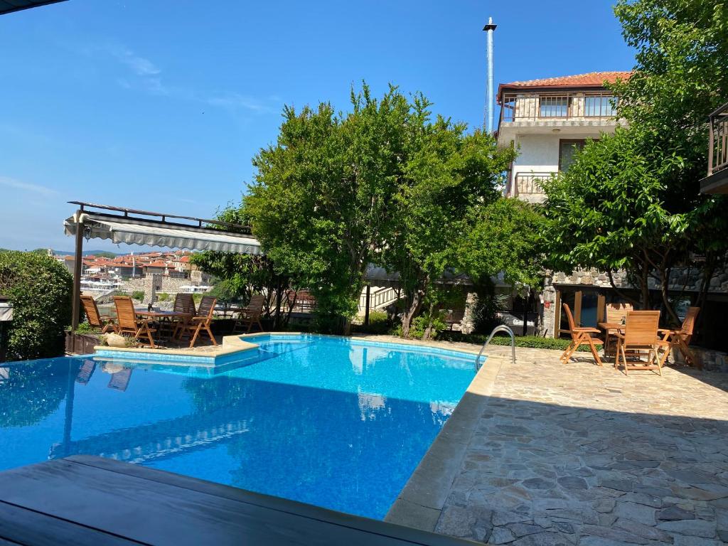 a large swimming pool with chairs and a building at Villas Sozopol in Sozopol