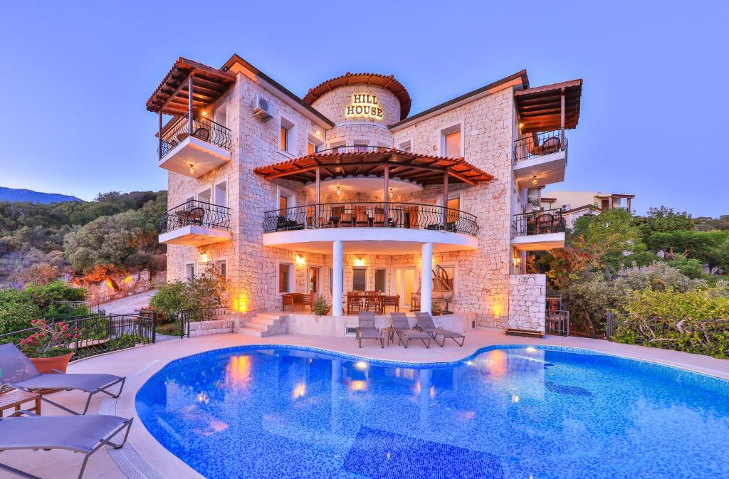 a large house with a swimming pool in front of it at Hill House Adult Only in Kaş