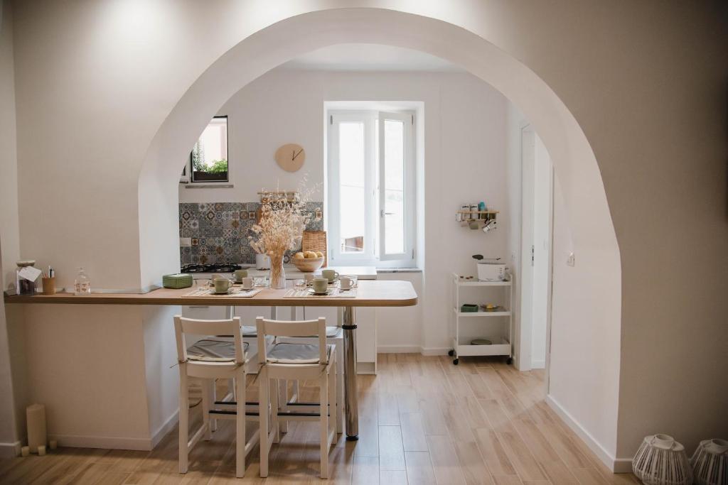 un arco en una cocina con mesa y sillas en Le Sorelle - casa vacanze, en Pisciotta