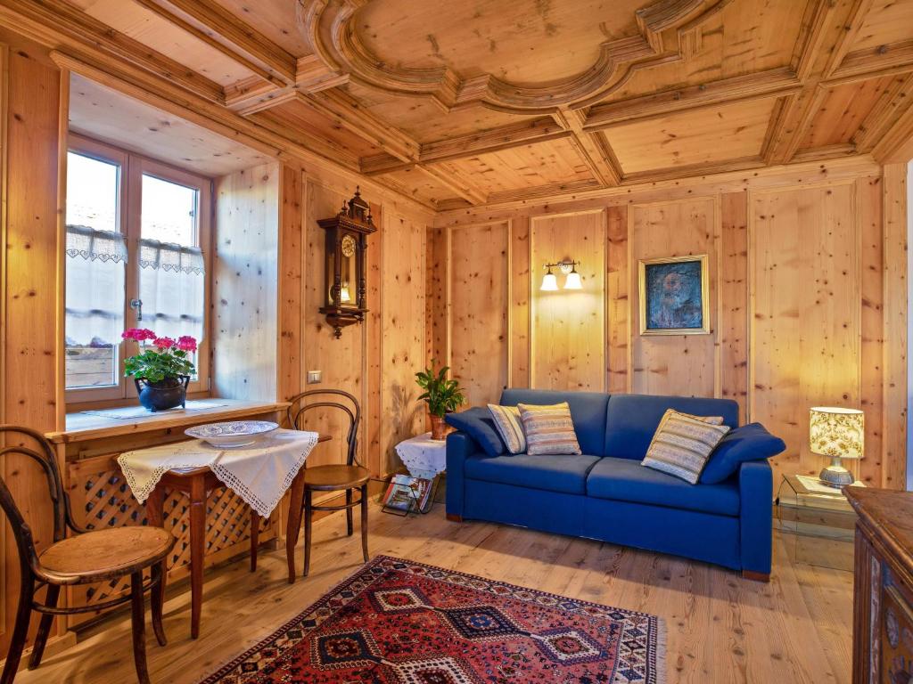 ein Wohnzimmer mit einem blauen Sofa und einem Tisch in der Unterkunft Casa Stella in Tesero