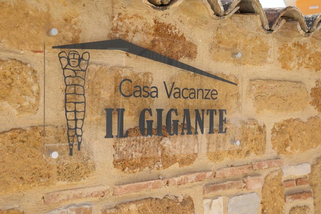 een bord aan de zijkant van een stenen muur bij Casa Vacanze IL GIGANTE in Agrigento
