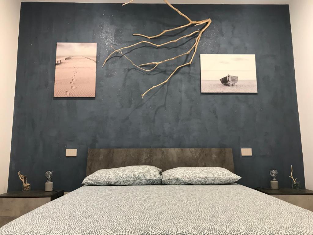 una camera con un letto con tre immagini appese al muro di Casa Patella a Lavagna