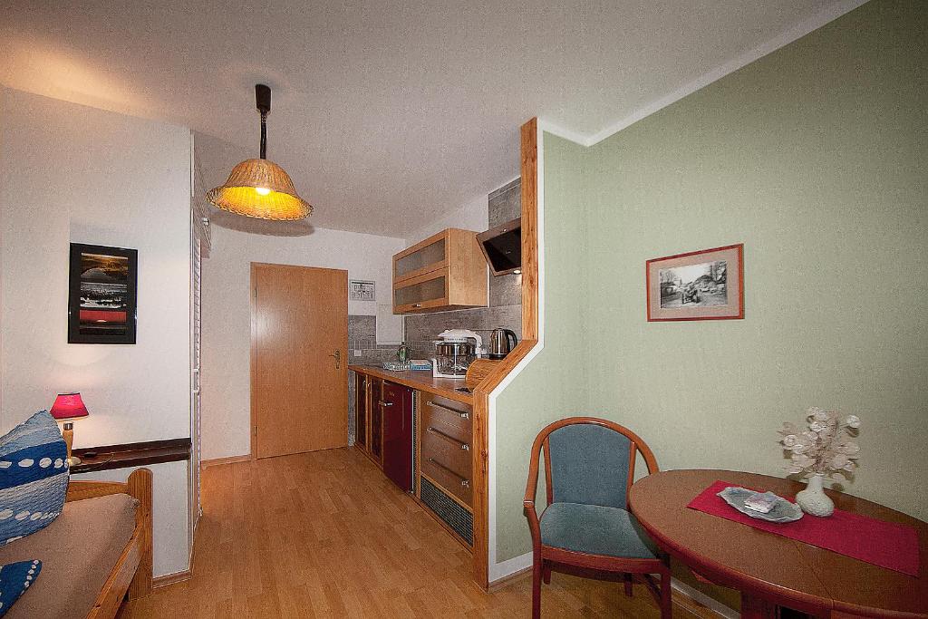 a small apartment with a table and a kitchen at Haus Müritz, FeWo 17 Hecht in Zielow