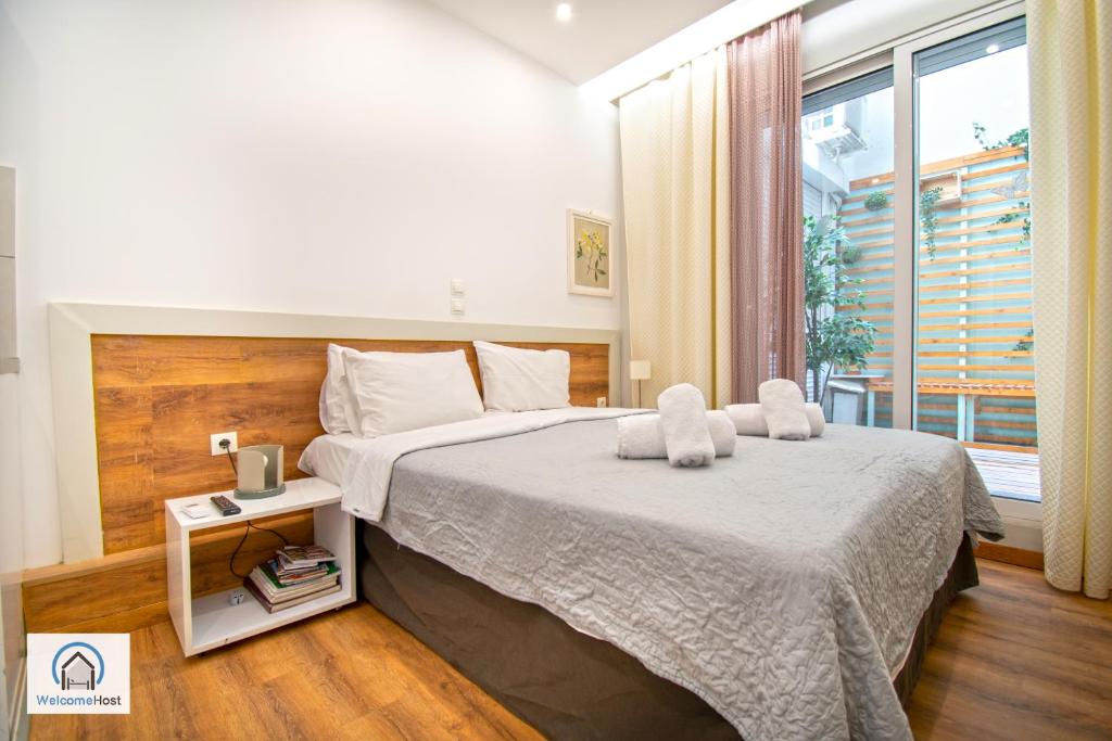 sypialnia z dużym łóżkiem i oknem w obiekcie Syntagma Square Athenian apartments w Atenach