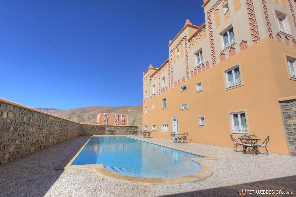 a swimming pool in front of a building at Hotel New Mars Dades in Aït Idaïr