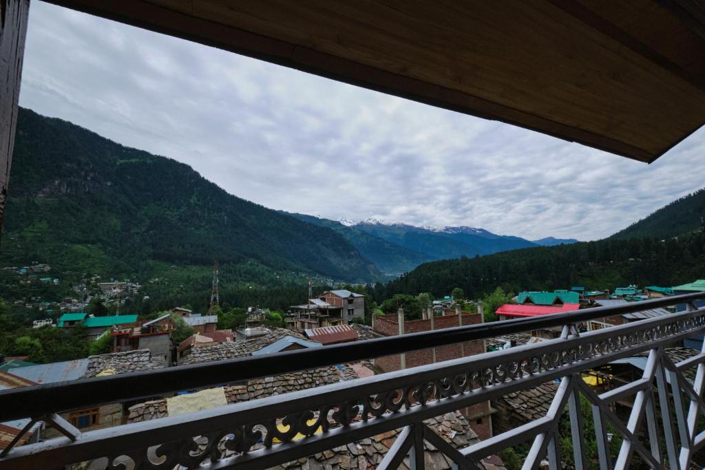 a view from a balcony of a town in the mountains at Voyageur Nest in Manāli
