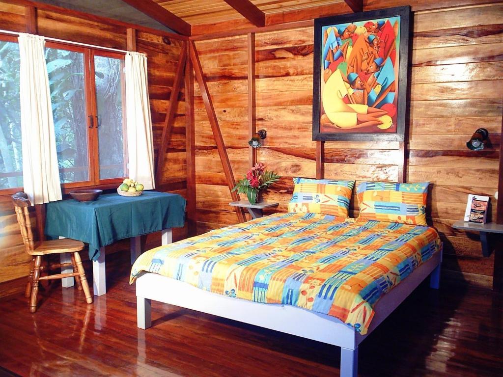 1 dormitorio con 1 cama en una cabaña de madera en El Tucan Jungle Lodge en Puerto Viejo