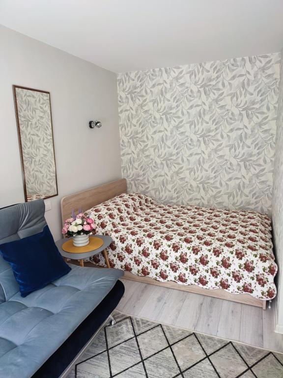 a small bedroom with a bed and a table at Upės apartamentai in Biržai