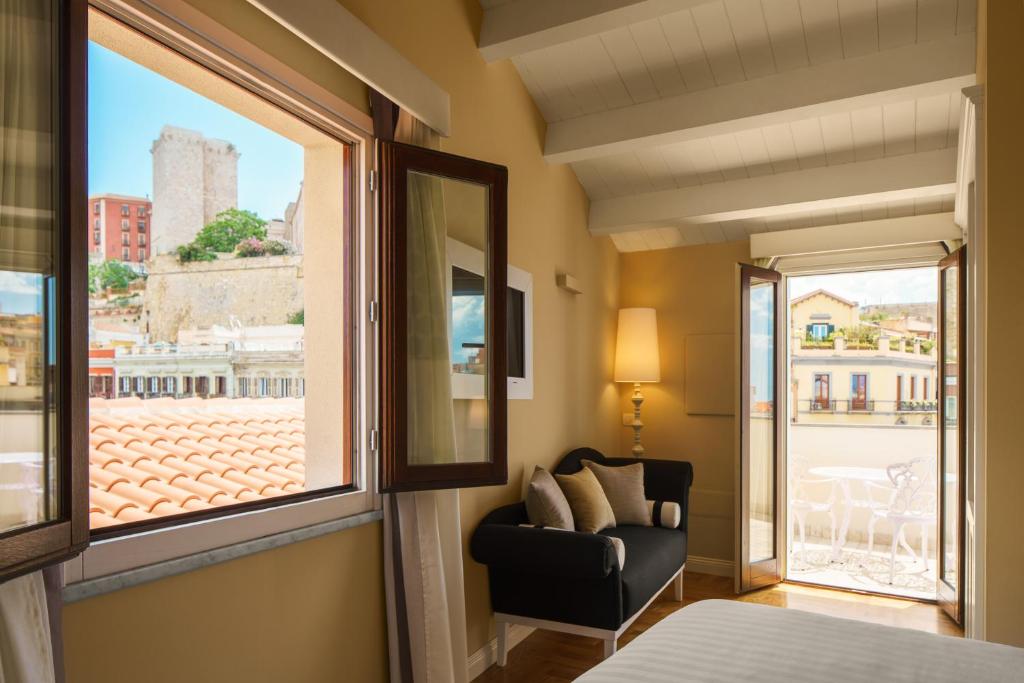 Habitación con silla y ventana en Boutique Hotel Carlo Felice, en Cagliari