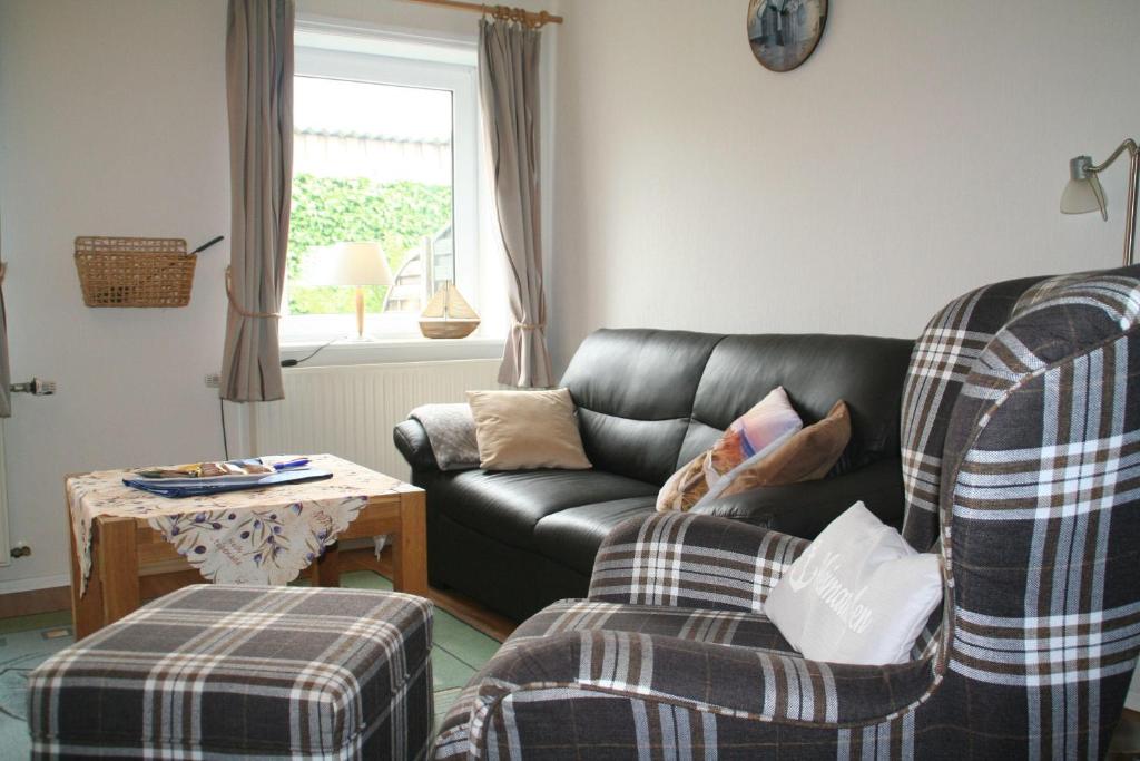 a living room with a couch and a chair at Wohnung-Wattwurm in Süderende