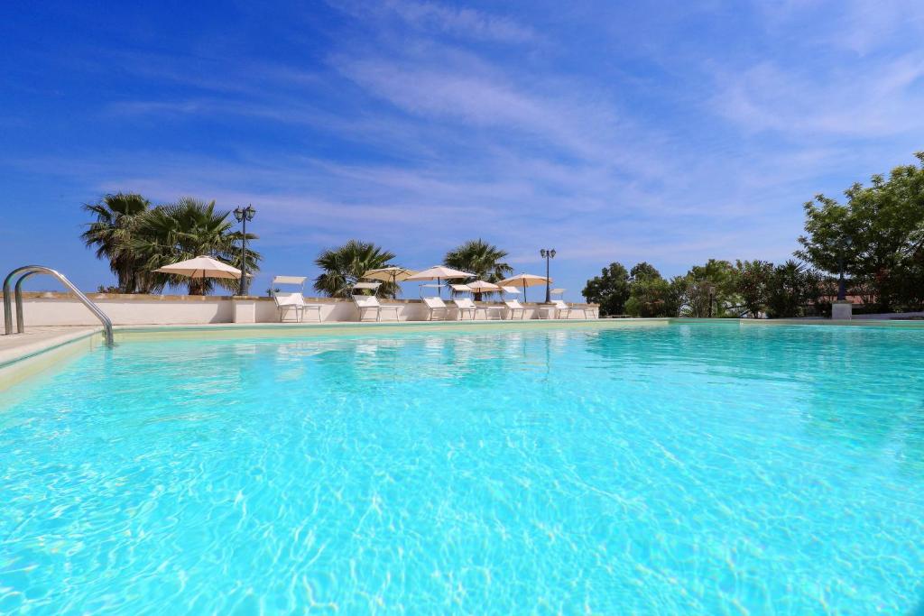 ein großer Pool mit blauem Wasser in der Unterkunft Tenuta Li Fani Residence Hotel in Marina di Pescoluse