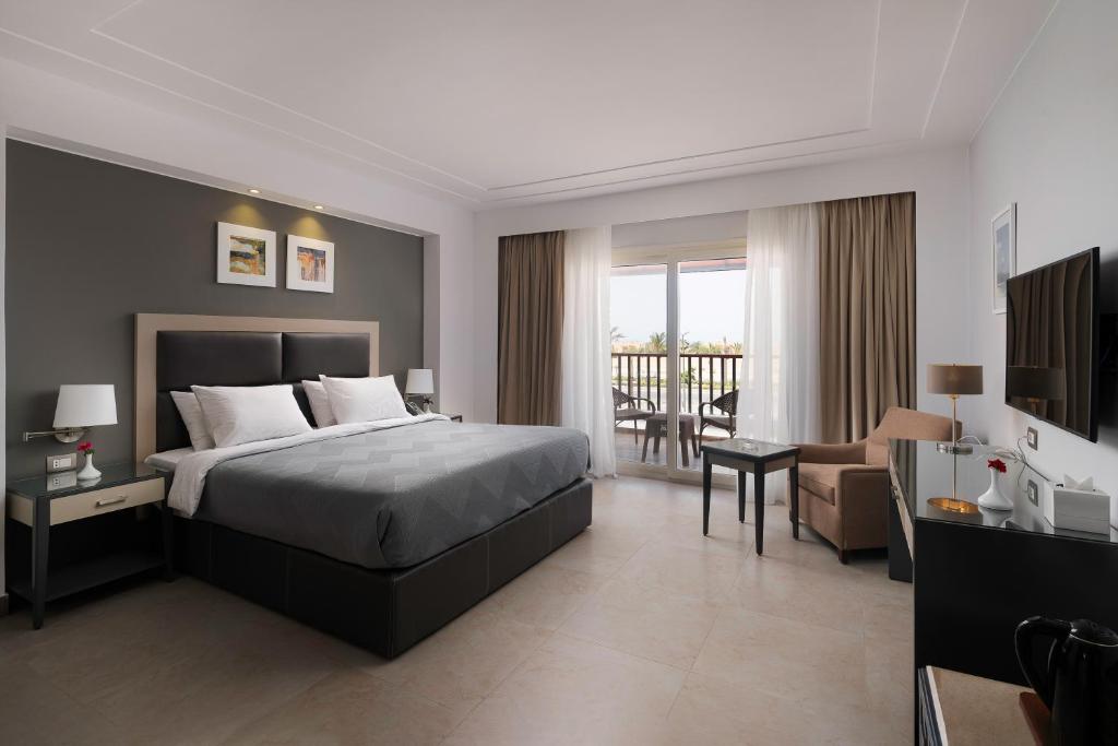 Rhactus Hotel, New Alamein في العلمين: غرفة نوم مع سرير وغرفة معيشة