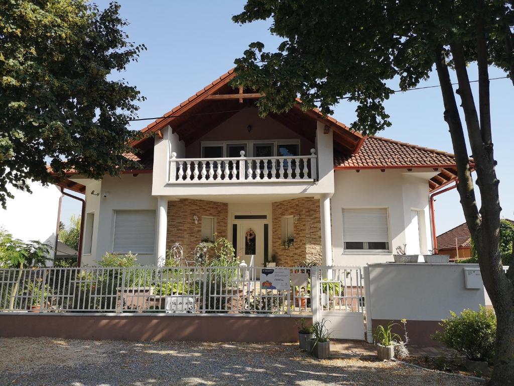 a house with a balcony and a fence at Csillag ház in Mosonmagyaróvár