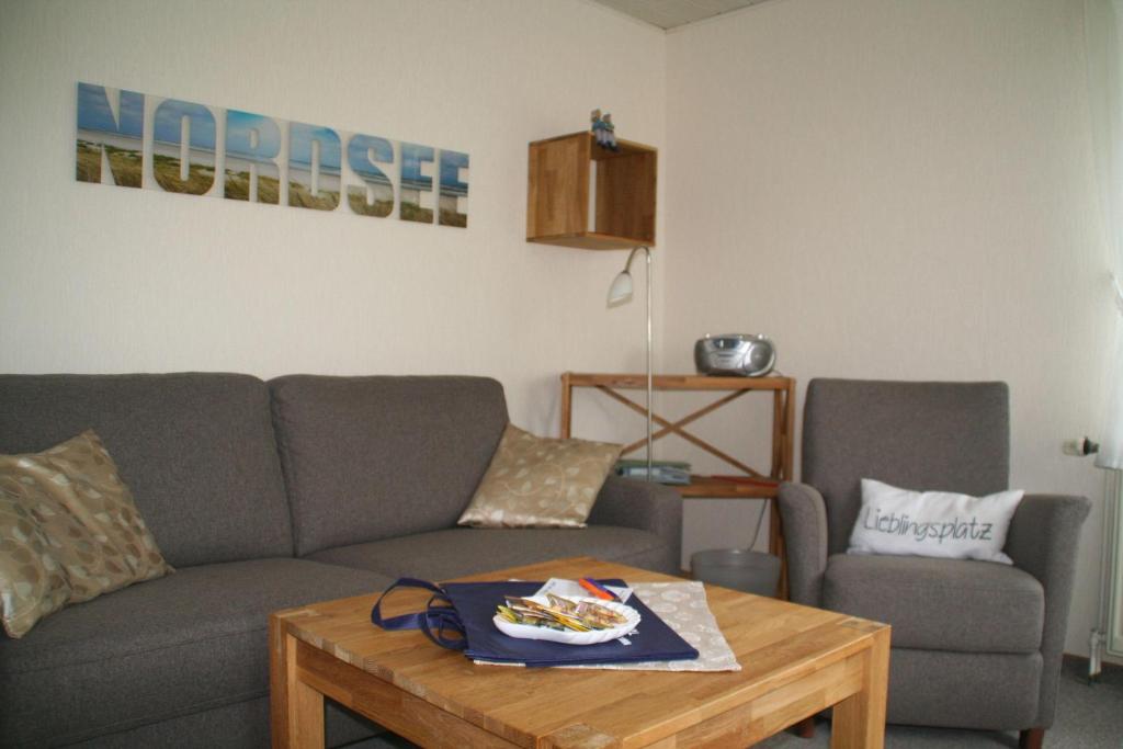 ein Wohnzimmer mit einem Sofa und einem Tisch in der Unterkunft Wohnung Krabbe in Süderende