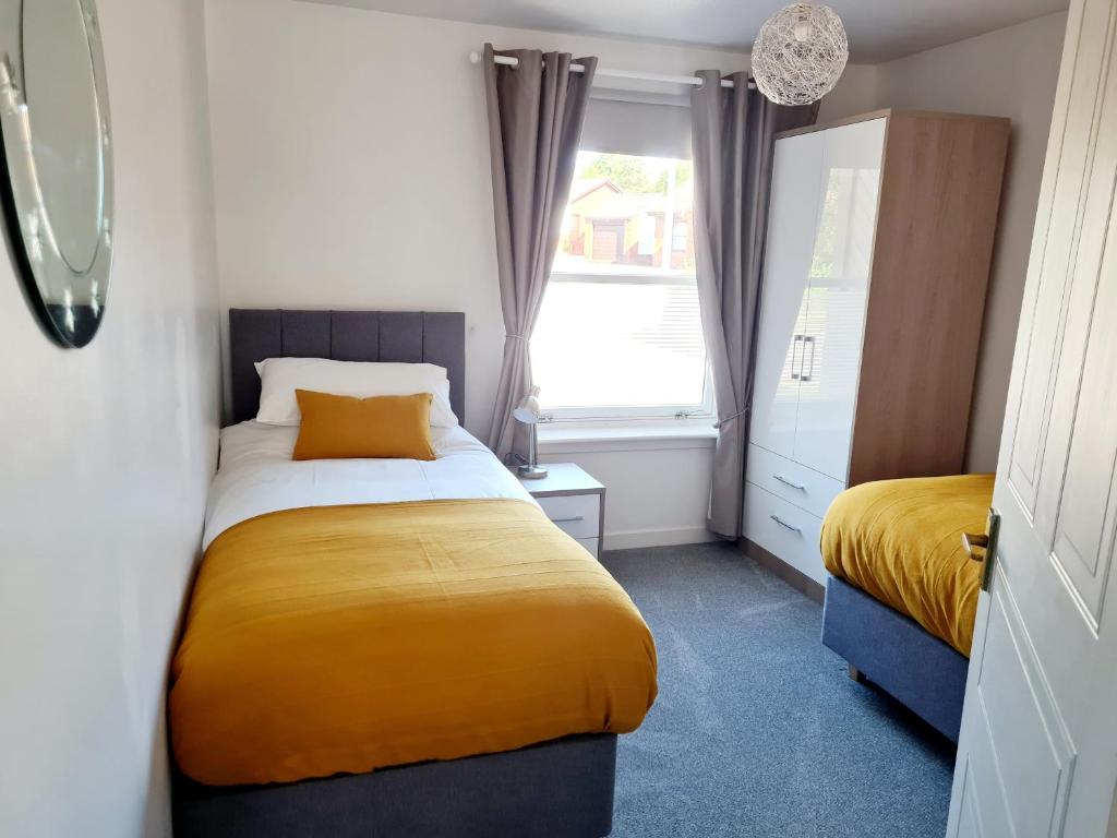 a small bedroom with a yellow bed and a window at Aviemore Stay & Explore in Aviemore