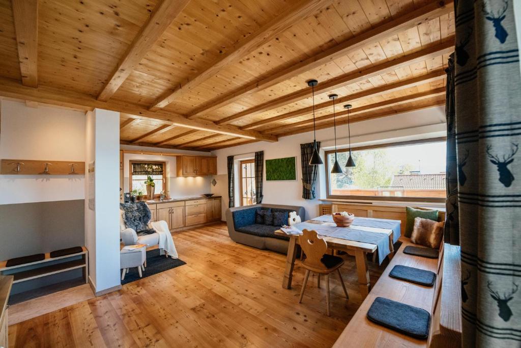 a living room with a wooden ceiling and a table at Apartment Judith - Gallhof in Vollan