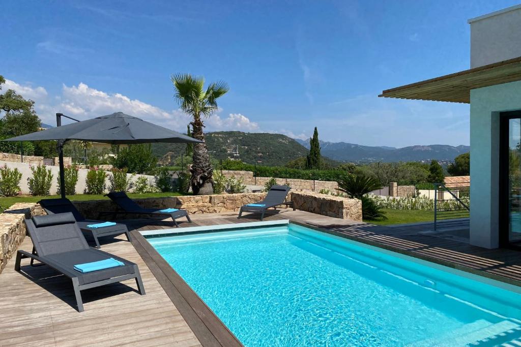 una piscina con dos sillas y una sombrilla en Villa Maria 12 pers piscine chauffée 5 min plage en voiture, en Sainte-Lucie de Porto-Vecchio
