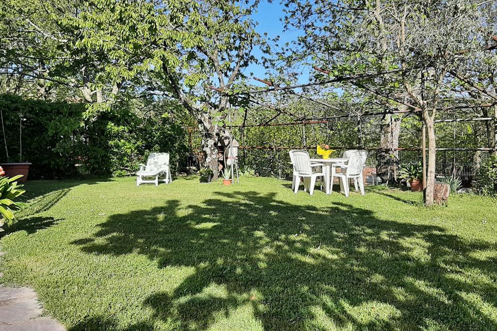 un cortile con due sedie e un tavolo nell'erba di Santa Fiora Ospitalità Diffusa - La Dimora del Marrone a Santa Fiora