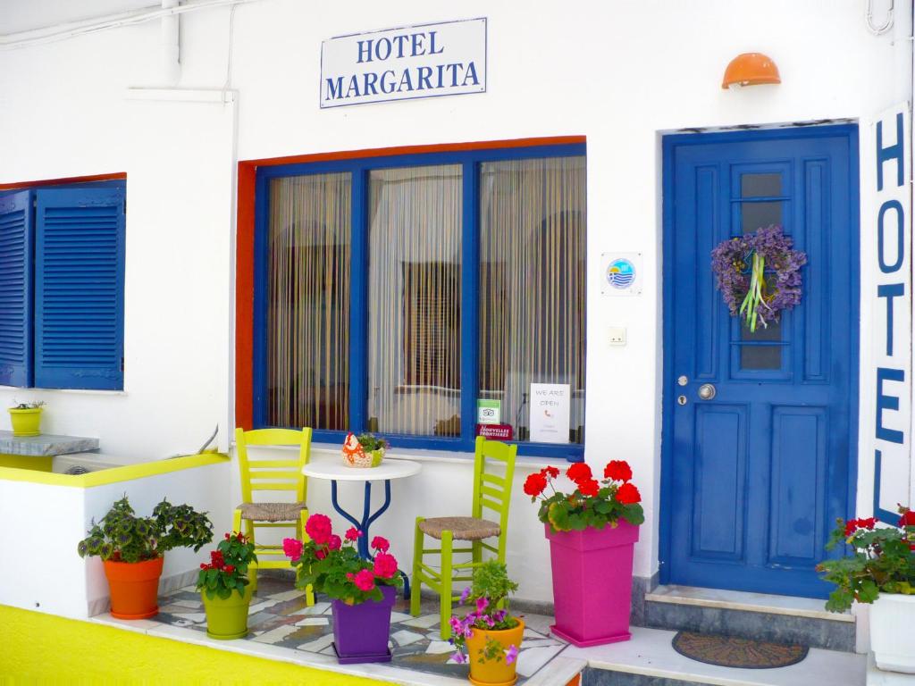 a Hotel Margarita mit bunten Stühlen und blauer Tür in der Unterkunft Viva Margarita in Parikia