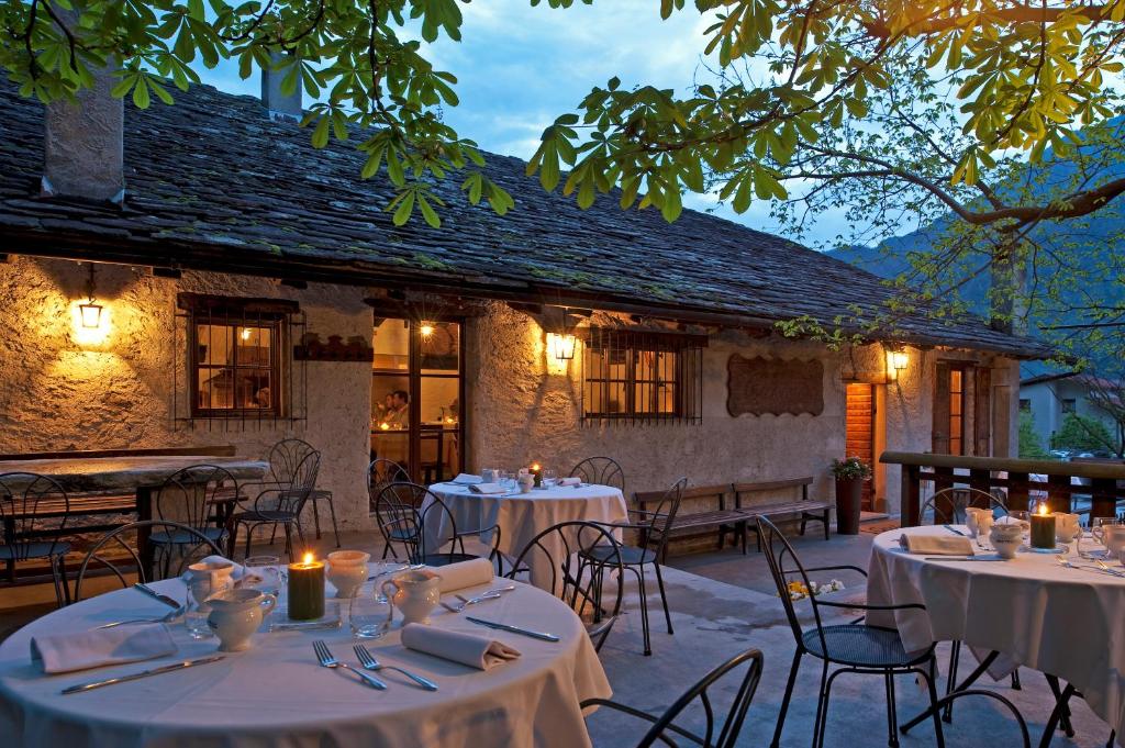 um restaurante com mesas e cadeiras em frente a um edifício em Foresteria Crotasc em Mese