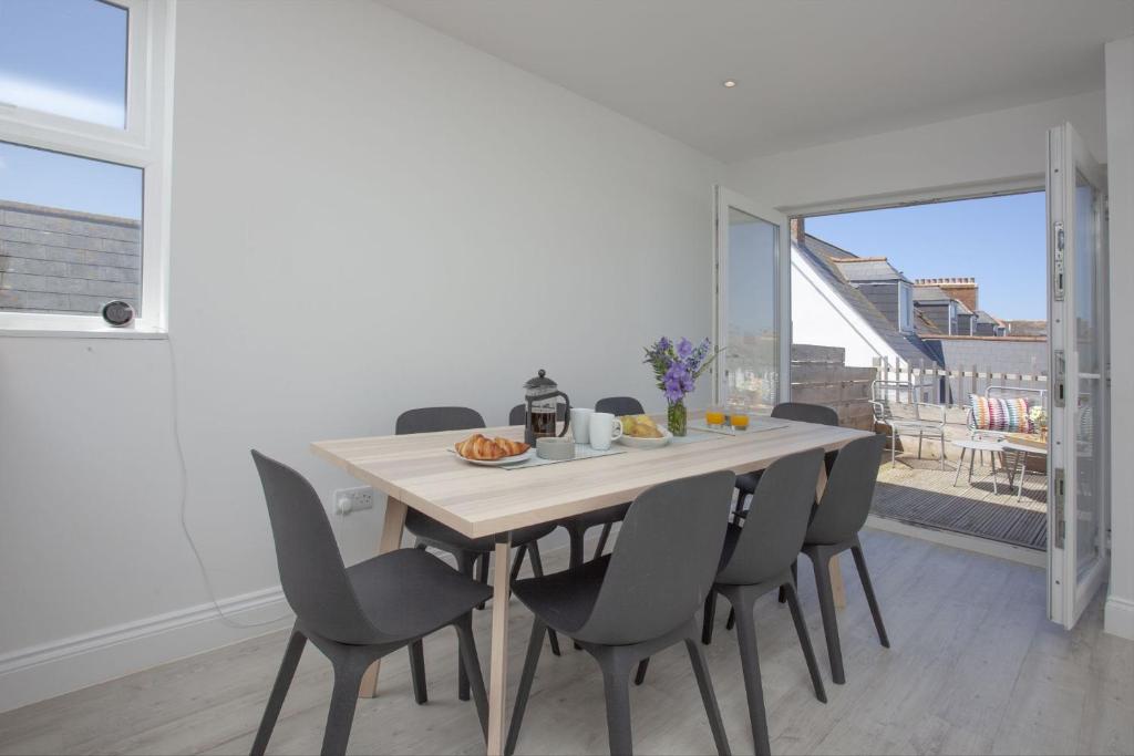 a dining room with a wooden table and chairs at Ocean View, Newquay in Newquay