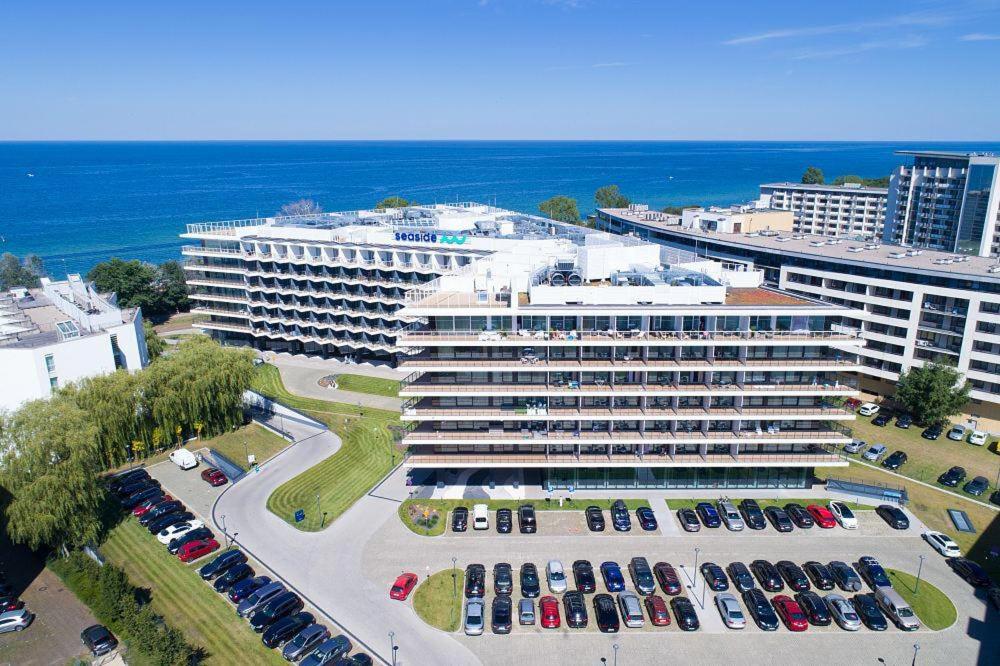 an aerial view of a large building with cars in a parking lot at NCM Apartments Seaside Park in Kołobrzeg