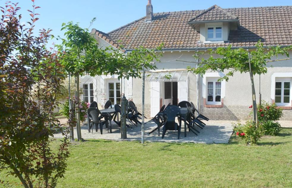 um grupo de pessoas sentadas numa mesa em frente a uma casa em ZooParc de Beauval, gite du vivier em Seigy