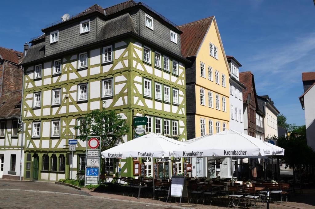 蘭河畔馬爾堡的住宿－Gartenlaube Marburg，前面有白色雨伞的黄色建筑
