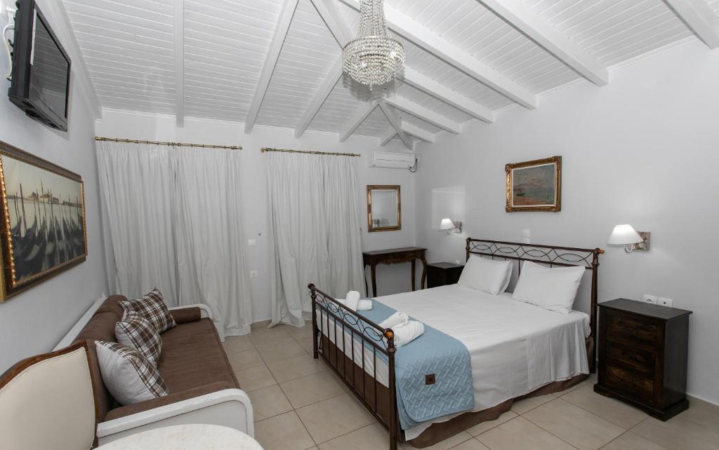 a bedroom with a bed and a couch and a chair at The Old Town hall in Parga