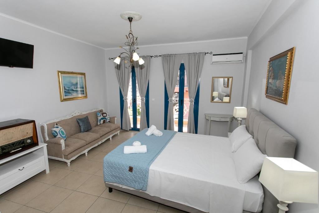 a bedroom with a bed and a couch at The Old Town hall in Parga