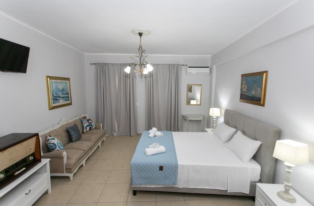 a bedroom with a bed and a couch at The Old Town hall in Parga