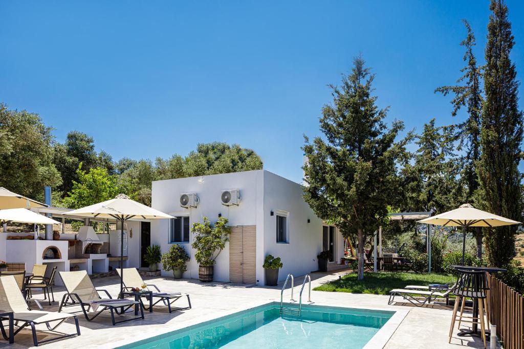a villa with a swimming pool with chairs and umbrellas at MariAndry Villa, Enchanting Secluded Retreat, By ThinkVilla in Episkopi