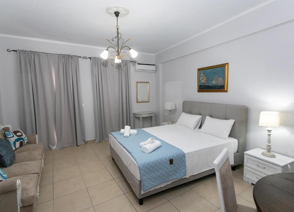 a bedroom with a large bed and a couch at The Old Town hall in Parga