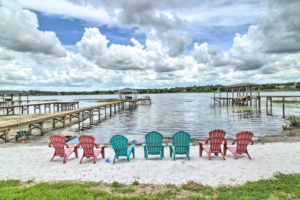 un grupo de sillas sentadas en la playa junto a un muelle en Florida Family Home with Private Pool and Dock!, en Clermont