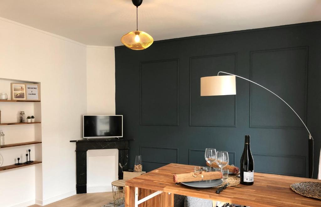 een kamer met een tafel met wijnglazen en een lamp bij Le Tanin -Appartement entier avec Balcon in Saumur