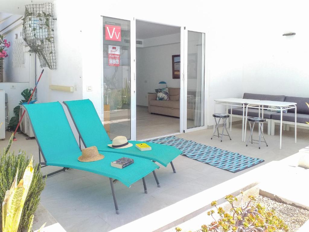 salon z niebieskim krzesłem i stołem w obiekcie Maki's Apartment w mieście Playa del Ingles