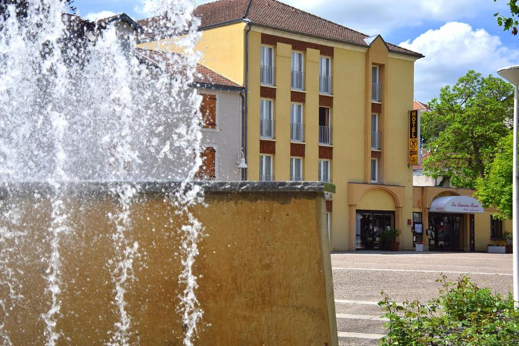 ブルボンヌ・レ・バンにあるHotel des Lauriers Rosesの建物前の噴水