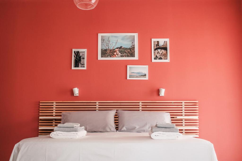 1 dormitorio con una pared roja y 1 cama en Magna Grecia B&B e Appartamenti, en Caulonia Marina