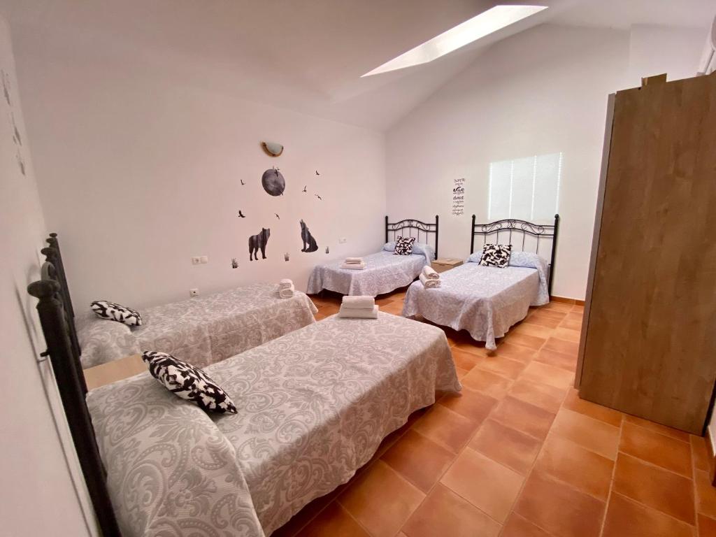 Habitación con 3 camas en una habitación en Alojamiento Los Tejos - Arroyo Frío, en Arroyo Frío