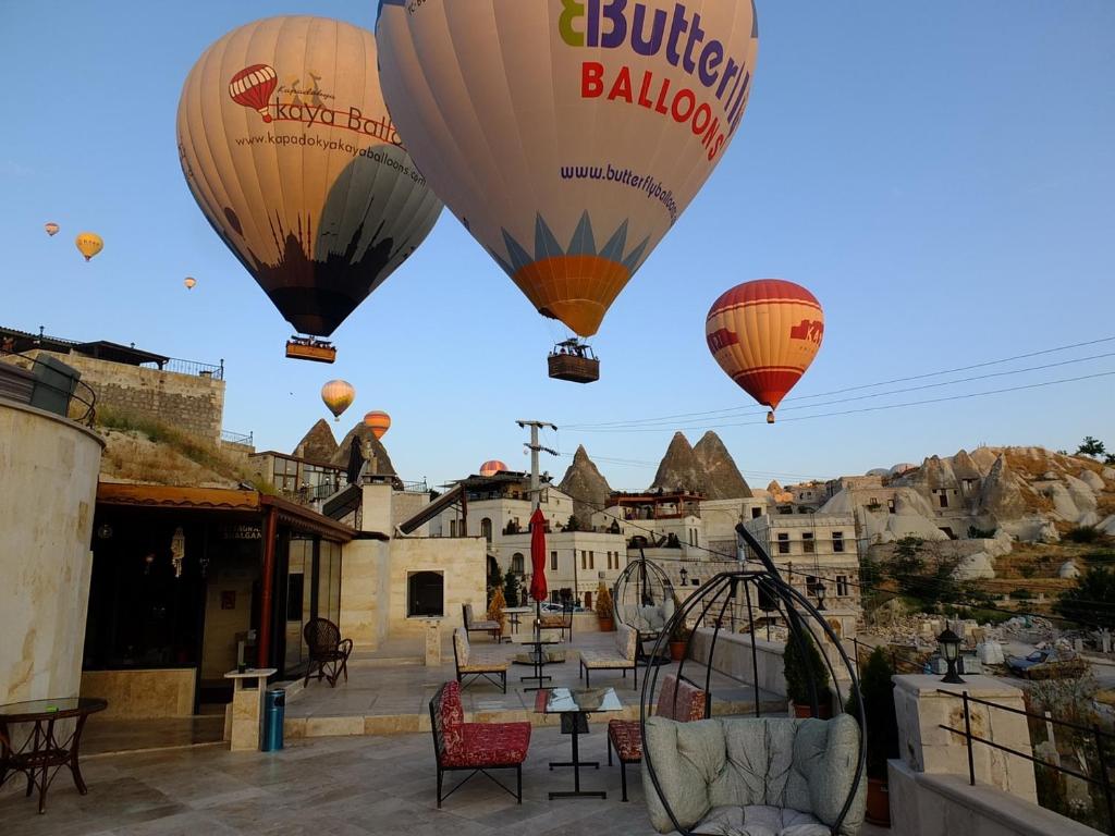 een groep heteluchtballonnen die in de lucht vliegen bij Balloon Cave Hotel in Goreme