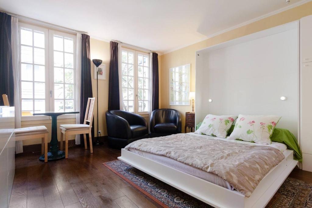 Schlafzimmer mit einem Bett, einem Schreibtisch und Stühlen in der Unterkunft Paris Saint Michel Sorbonne in Paris